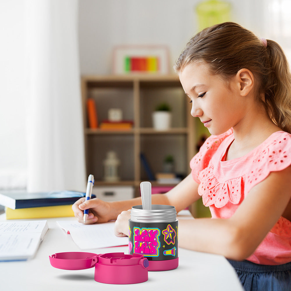 Girl sitting at table doing homework with an open 10 ounce Funtainer food jar open next to her. 