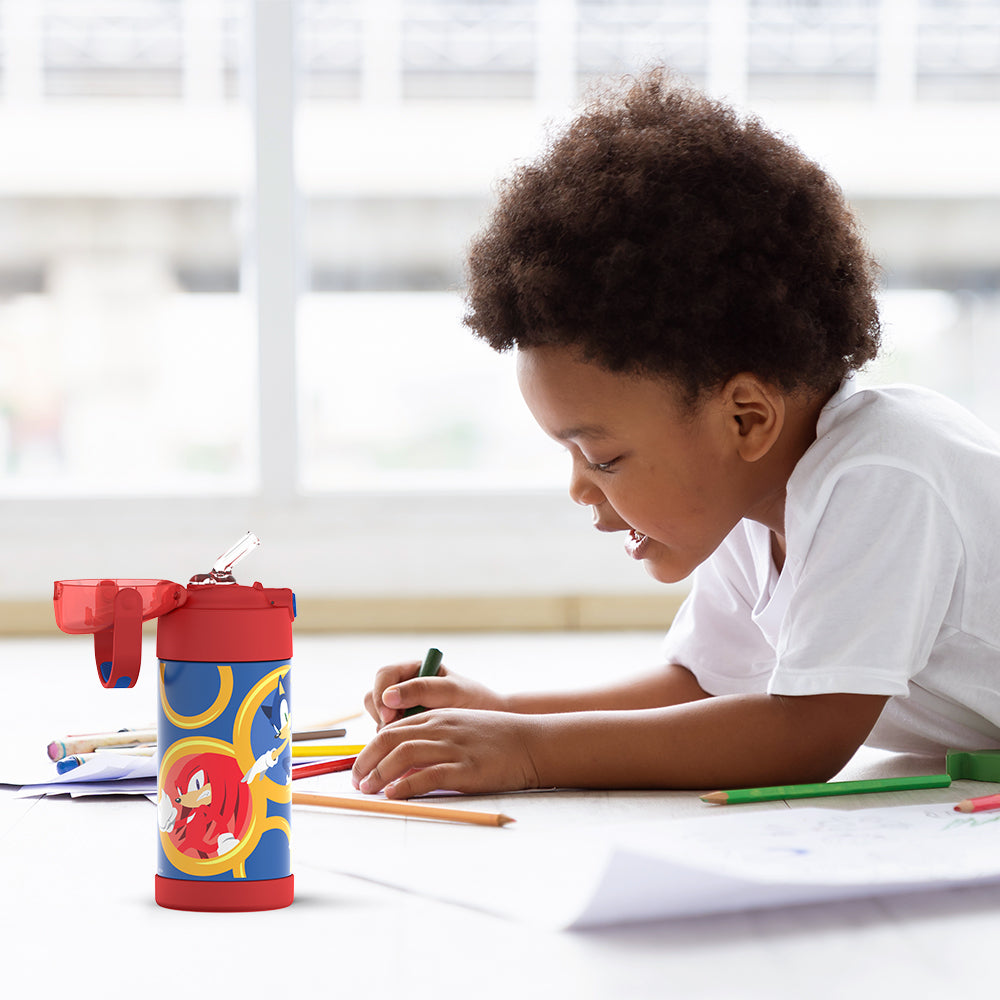 Boy sitting at a table coloring, with the 12 ounce Funtainer Sonic the Hedgehog, Red water bottle opened next to him.